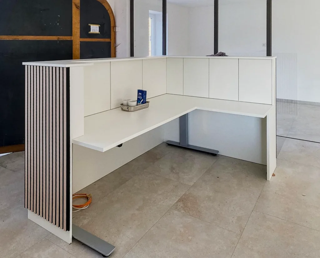 Weiße Küchenzeile mit Eckarbeitsplatte und Schrankfronten, Unterbau mit Platz für Geräte, im Raum.