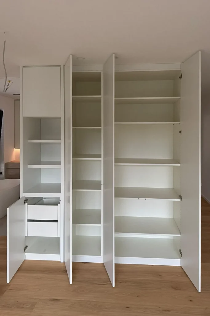 Offenes Küchenelement mit hohen Schrankfächern und Einlegeböden sowie ausklappbarer Schublade in weiß.