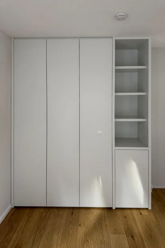 Schrankwand mit weißen Türen und offenem Einlegefachregal, in der Küche an der Wand montiert