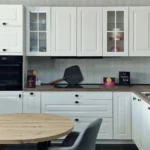 Küchenzeile in Magnolia mit Hängeschränken, Backofen, Arbeitsplatte und Spülbecken.