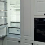 Einbau-Kühlschrank mit Tür und integrierter Backofen mit Display in einer hellen Küchenzeile