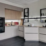 Moderne L-förmige Einbauküche mit Backofen, Kochfeld, Spüle, weißen Schränken und LED-Unterbau